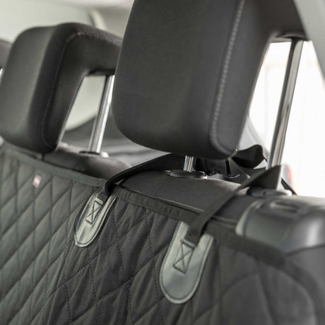 Car seat cover with a quilted pattern and brand logo on a car seat.