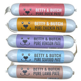 Five packages of Betty & Butch pet food with different flavors on a white background